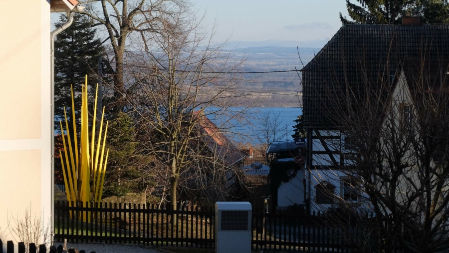 An einem späten Februar-Nachmittag in Jauernick-Buschbach: Die Abendsonne beleuchtet die Goldene Ähre, den Berzdorfer See und im Hintergrund die Landschaft bis hin zu den Ausläufern der Sudeten